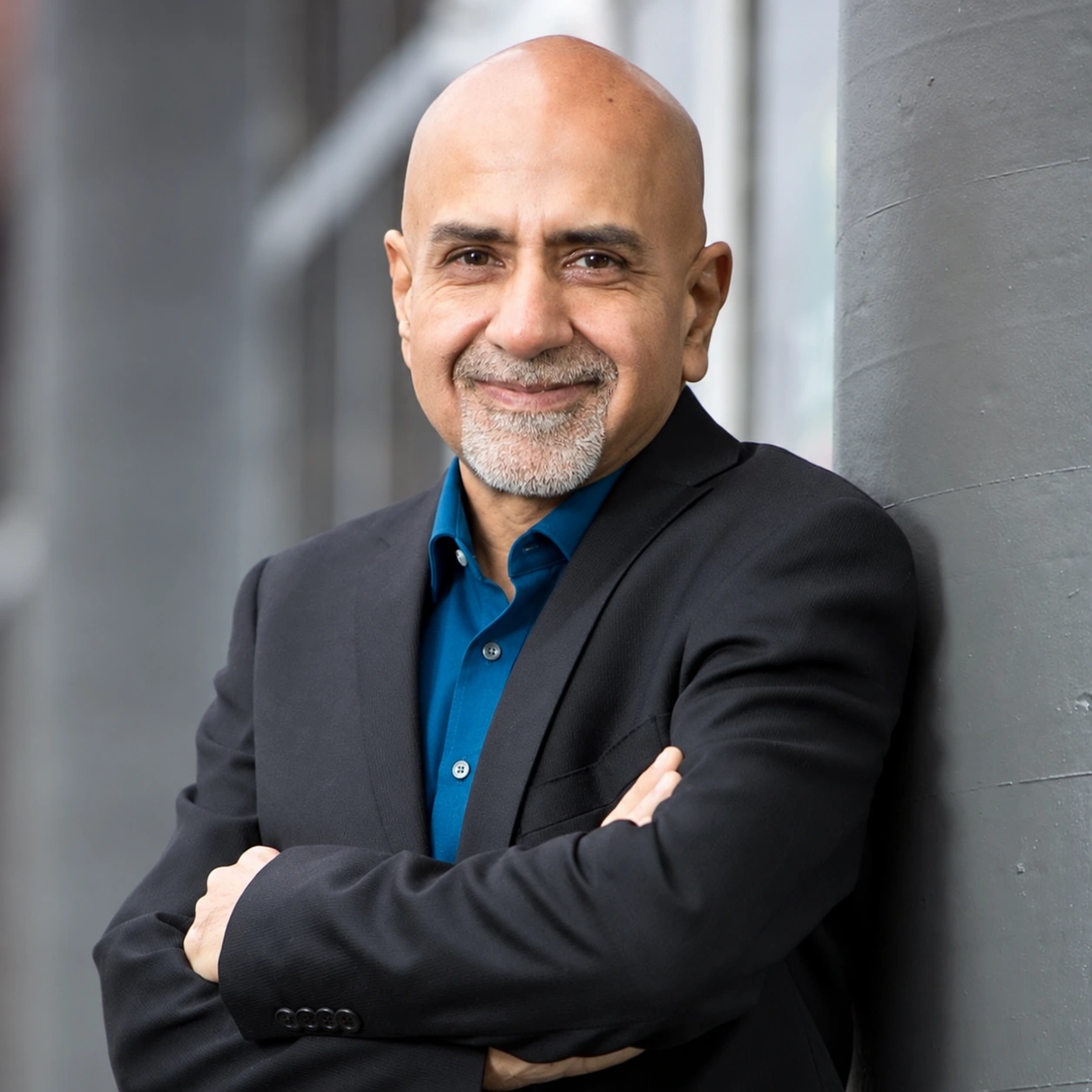 Ishaq Ismail in a dark suit and open-collar blue shirt